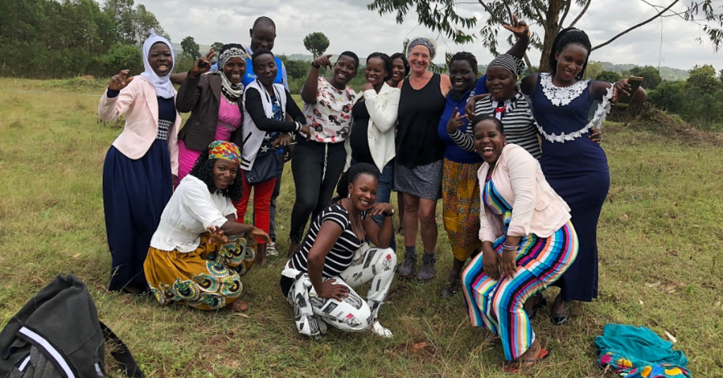 A group of Ugandan women smile and pose with researcher, Shelley Jones.
